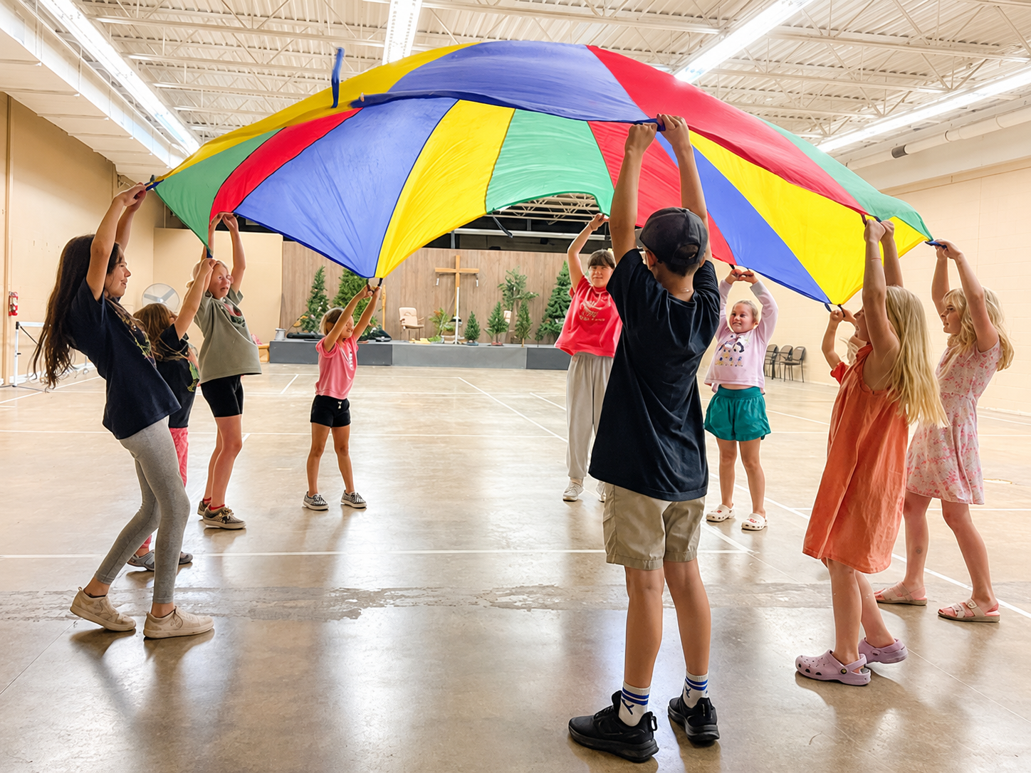 Kids playing beneath a raised parachute